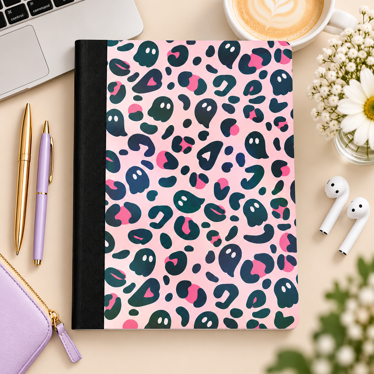 Pink ghost-pattern composition book styled on a desk, without the label