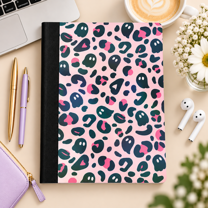 Pink ghost-pattern composition book styled on a desk, without the label
